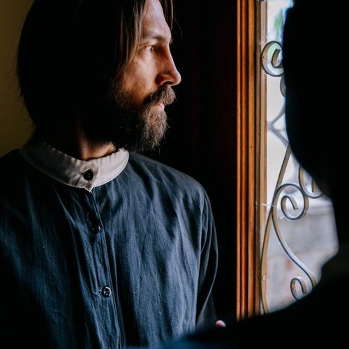 Man in a calm, focused state after completing a workout, looking out a window.